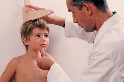 Un médico mida a un niño.