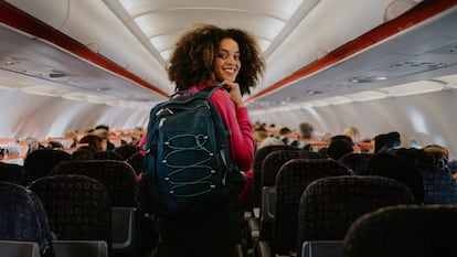 Una chica con su mochila entrando a un avión.