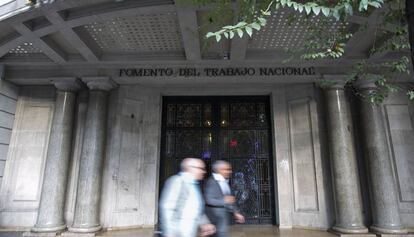 Dos hombres pasean por delante de la puerta de la Patronal