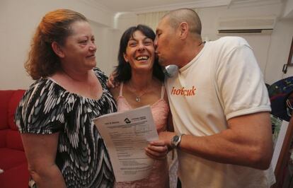 Ana Mar&iacute;a G&oacute;mez (center) with the expropriation document that saves her from eviction. 