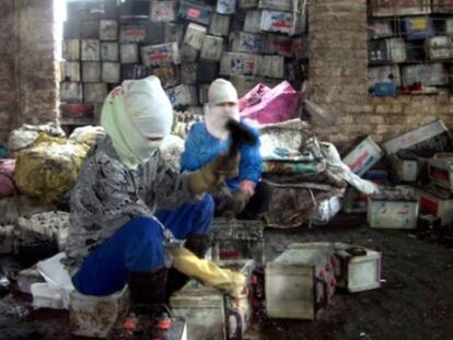 Dos jóvenes desmontan baterías viejas en Vietnam.