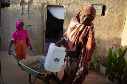 Sana Ibrahim Abdel Rehman, de nueve años, ayuda a su hermana Amina, de 24, a descargar bidones en su casa en el campamento de desplazados internos de Abu Shouk, en Darfur del Norte, Sudán, en una imagen tomada el mes pasado por Unicef.