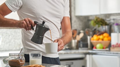 un hombre echándose el café de una cafetera italiana.