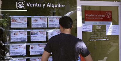 Escaparate de una inmobiliaria en Madrid, con anuncios de pisos en venta.
