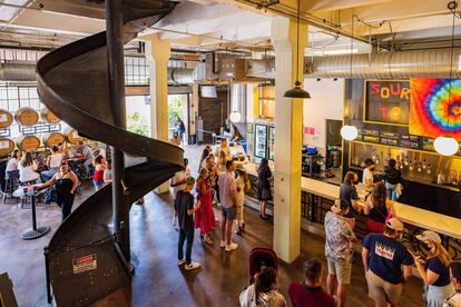 La Angel City Brewery, una cervecería dentro de una nave industrial decorada con cuadros y objetos variados.