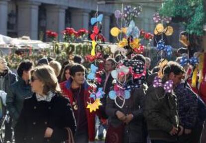 Varias personas visitan la Plaza Mayor de Madrid donde se encuentran instaladas diversas casetas en las que se pueden comprar artículos navideños y otros elementos de diversión para estas fiestas.