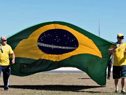 Dos manifestantes con una bandera de Brasil en una marcha a favor de Bolsonaro en Brasilia el 1 de mayo.