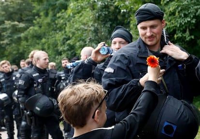 Un niño regala una flor a un policía durante la manifestación contra la cumbre del G-20 en Hamburgo (Alemania), el 8 de julio de 2017.