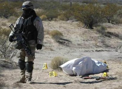 Un soldado mexicano pasa junto al cuerpo de uno de los sicarios fallecidos en el tiroteo