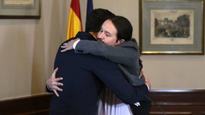 Pedro Sánchez and Pablo Iglesias embrace after signing the deal.