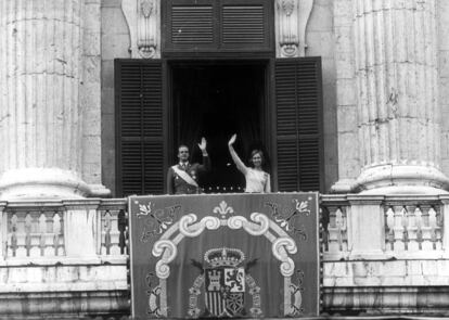 El rey Juan Carlos y la reina Sofía saludan desde el balcón del Palacio Real en la plaza de Oriente tras la coronación.