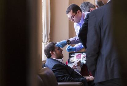 Junqueras es atendido tras su caída en el Parlament.