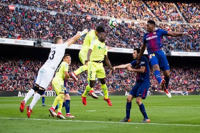 Yerry Mina lanza con la cabeza la pelota a la portería del Getafe.