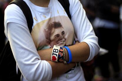 Una joven espera en el exterior del Palacio de Deportes el concierto del cantante Justin Bieber.