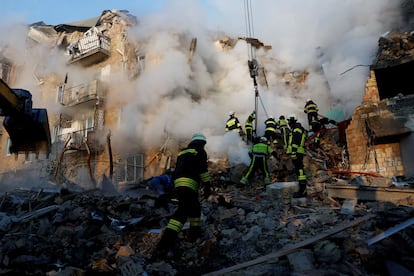 Equipos de rescate trabajan en un edificio de apartamentos alcanzado por misiles rusos este jueves en Kiev.