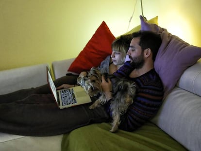 Una pareja ve una película en el ordenador portatil. 