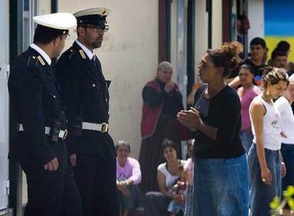 Policías locales hablan con una mujer en el campamento gitano de Il Salone, a las afueras de Roma.