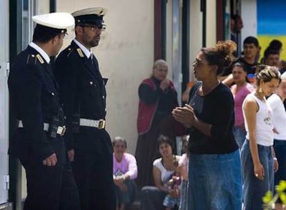 Policías locales hablan con una mujer en el campamento gitano de Il Salone, a las afueras de Roma.