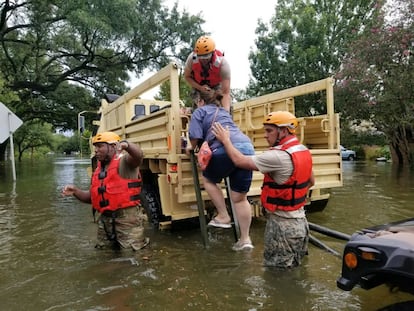 Os soldados da Guarda Nacional do Texas ajudam os cidadãos em zonas fortemente alagadas pelas tormentas do furacão Harvey em Houston.