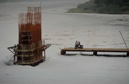 Dos jóvenes indios observan las obras de construcción del puente sobre el río contaminado Yamuna, en Neva Delhi (India).