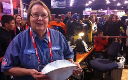 Jane Helser muestra un balón del revés recién cosido en la máquina, el sábado en la feria de NFL en Phoenix.