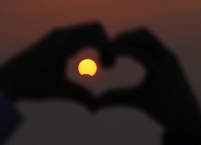 Kuwait, el eclipse de Sol h&iacute;brido, a trav&eacute;s de la figura de un coraz&oacute;n hecho con las manos. 