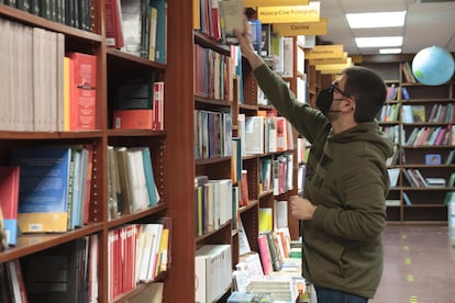 Un trabajador coloca libros en una librería.