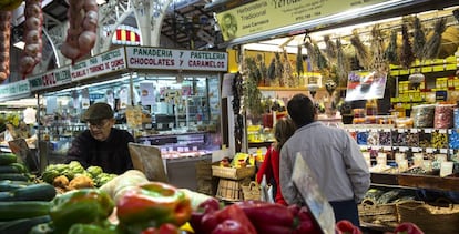 Puesto de frutas y verduras y una panadería, en el Mercado Central de Valencia.