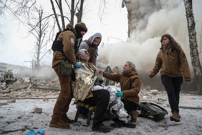 Medical workers treat a wounded local resident at a site of residential buildings heavily damaged during a Russian missile attack.