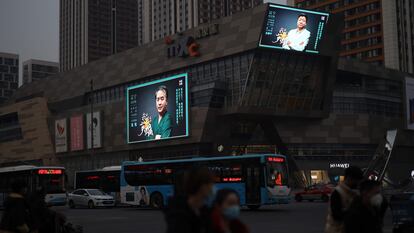 Uma rua da cidade chinesa de Shenyang, nesta quarta-feira. Nas telas, um programa de homenagem aos médicos que viajaram a Wuhan.