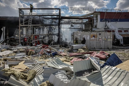 Los bomberos trabajando, en una vista exterior del supermercado impactado por el misil ruso.