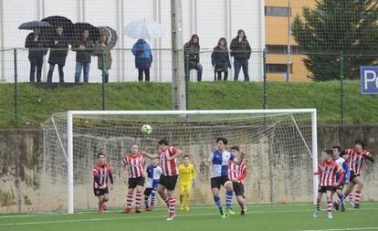 Partido de fútbol base con los padres fuera del recinto.