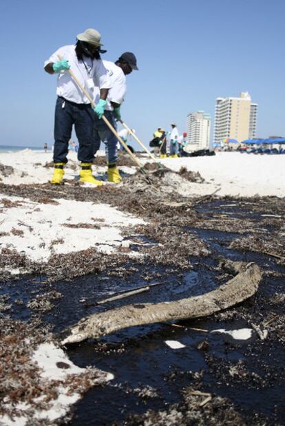 Empleados de BP limpian las manchas de petróleo, el pasado junio, en las costas de Alabama.