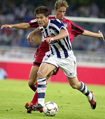 Xabi Alonso conduce la pelota con Fernando Torres detrás.