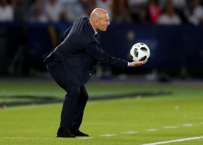El entrenador del Real Madrid, Zinedine Zidane, recoge el balón.