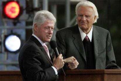 Billy Graham (derecha) sigue la intervención de Bill Clinton durante el homenaje al predicador en Nueva York.