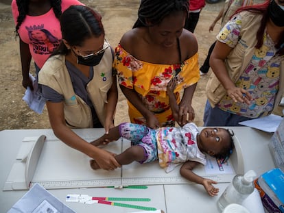 Una trabajadora de Acción contra el Hambre atiende a una niña migrante en el municipio de El Paraíso, Honduras, el 5 de julio de 2022.