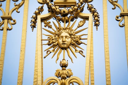 Detalle de la verja cubierta de pan de oro del Palacio de Versalles, con el símbolo de Luis XIV, el Rey Sol.
