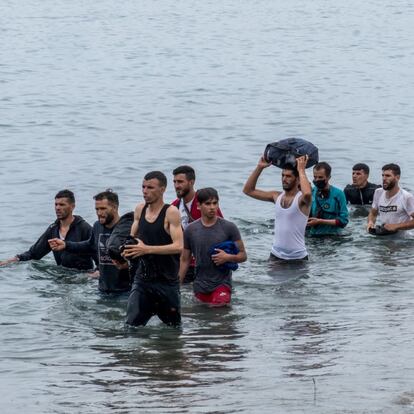 Un grupo de inmigrantes procedentes de Marruecos salen del agua tras cruzar a nado la frontera. El Ministerio del Interior ha informado este martes a media tarde que ha tramitado ya la devolución de unos 4.000 inmigrantes, la mitad de los cerca de 8.000 que han accedido a Ceuta de forma irregular desde ayer. Además, ha habilitado un sistema de gestión de 24 horas para agilizar estos trámites y un nuevo aumento de efectivos policiales en la zona.