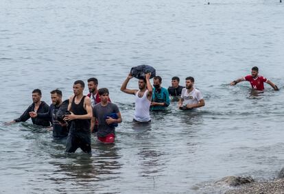 Un grupo de inmigrantes procedentes de Marruecos salen del agua tras cruzar a nado la frontera.