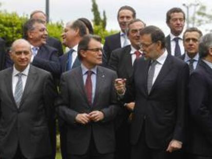 El jefe del Gobierno, Mariano Rajoy (2º d), ha elogiado hoy en Barcelona, ante el presidente de la Generalitat, Artur Mas (2º i), el papel de Cataluña "como un punto de encuentro, un lugar de convivencia y un espejo de la pluralidad de España", después de posar para la foto de familia previa a la comida con empresarios del sector del automovilismo.