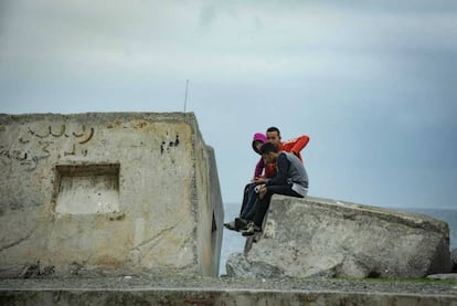 Tres menores sentados frente al mar en Ceuta, el pasado viernes.