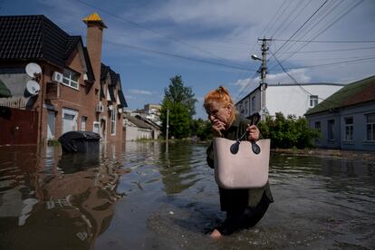 A local resident makes her way through a flooded road after the Russian troops blew the Kakhovka dam overnight, in Kherson, Ukraine