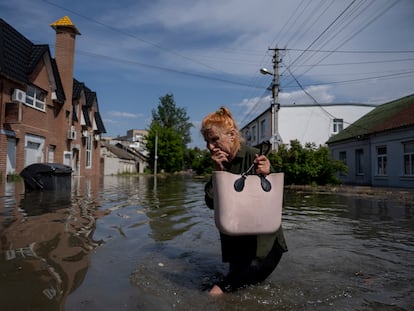 A local resident makes her way through a flooded road after the Russian troops blew the Kakhovka dam overnight, in Kherson, Ukraine, June 6, 2023.