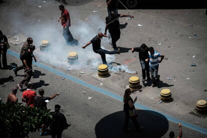 Manifestante chuta bomba de gás lacrimogêneo.