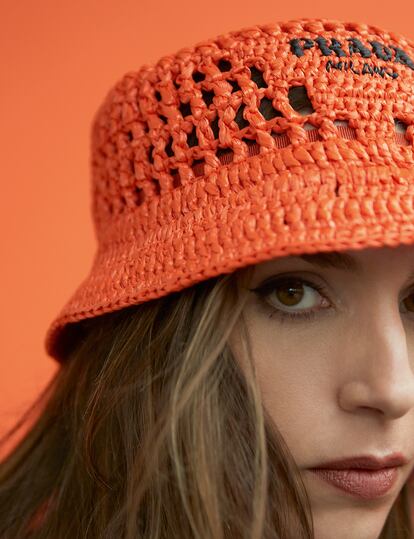 Laura lleva gorro de croché naranja de PRADA.