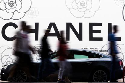 Varias personas pasean por delante de un cartel de Chanel en Ginebra (Suiza).