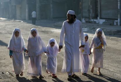 Niñas acompañadas de su padre durante la festividad del Eid al Adha en Duma cerca de Damasco (Siria), el 4 de octubre de 2014.