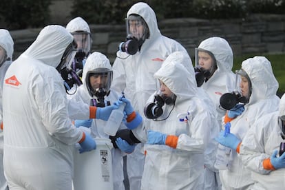 Trabajadores con protección se preparan para desinfectar de coronavirus una residencia cerca de Seattle (EE UU).