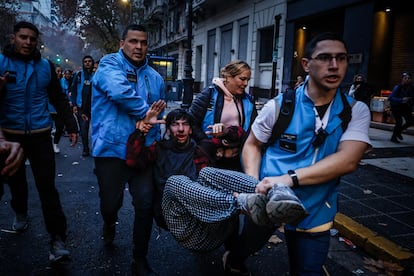 Un hombre herido recibe ayuda tras enfrentarse con policías, este miécoles en Buenos Aires.